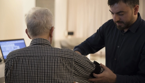 Man fitting patient wearable 