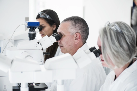 Scientists looking at microscope