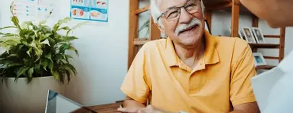 רופא משוחח עם מטופל בכיר מחייך