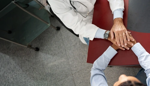 Un medico tiene le mani a un paziente 