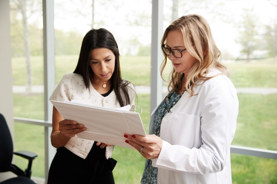 business-person-and-doctor-look-at-a-report-5-0