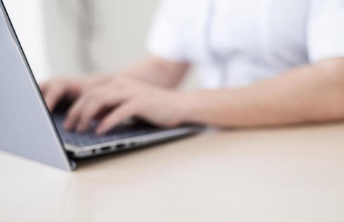 Zorgverlener typt op een laptop