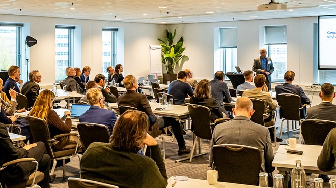 Groep professionals volgt een presentatie in een zaal