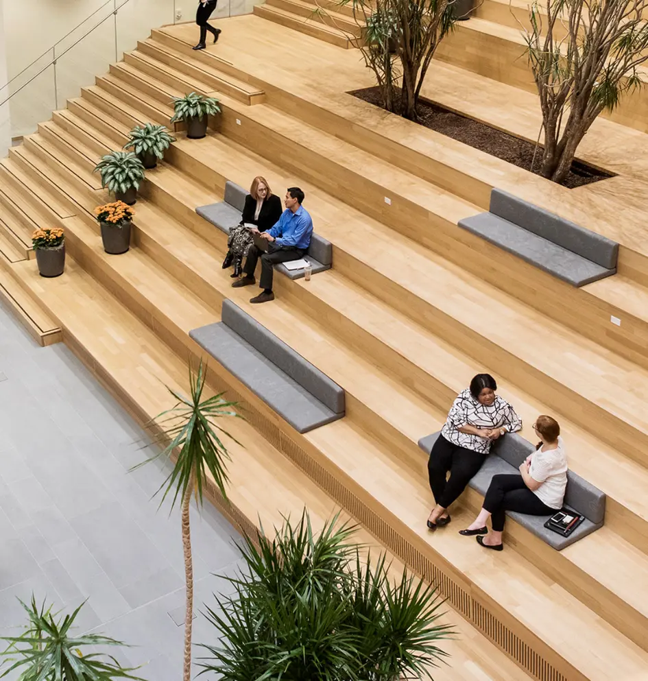 Persoane care discută într-o zonă de tip atrium modern