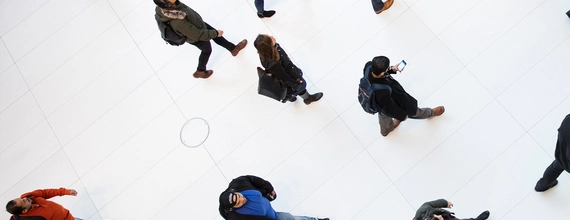 Vedere aeriană cu oameni mergând prin holul alb al unei clădiri moderne