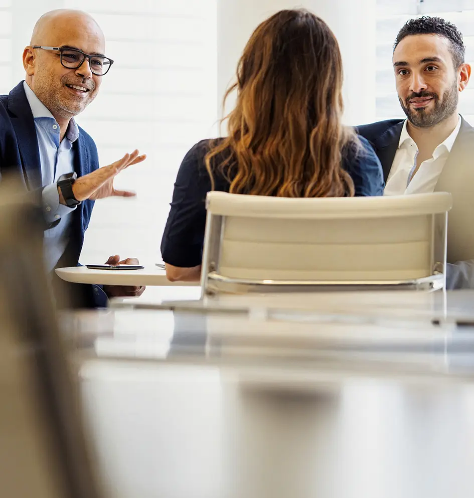Three professionals discussing business in a meeting in the office