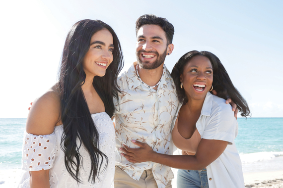 A group of friends hang out at the beach on a sunny day