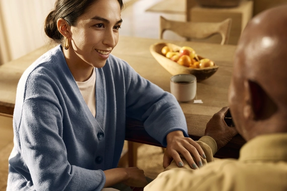 Starejša odrasla oseba in skrbnik imata pomirjujoč pogovor doma