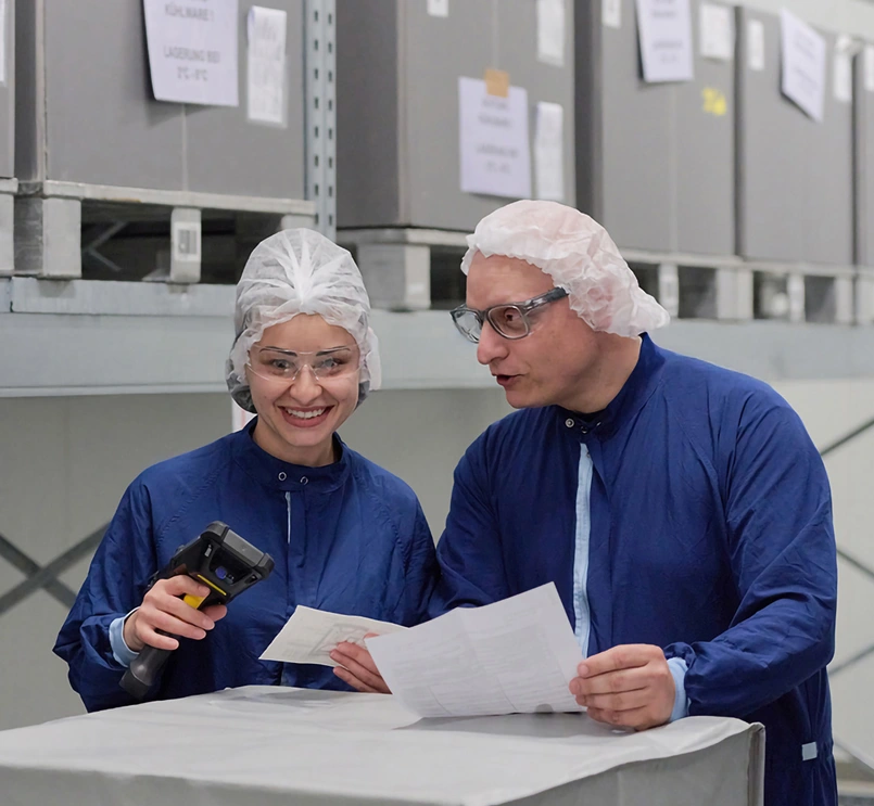 Two production specialists looking at documents