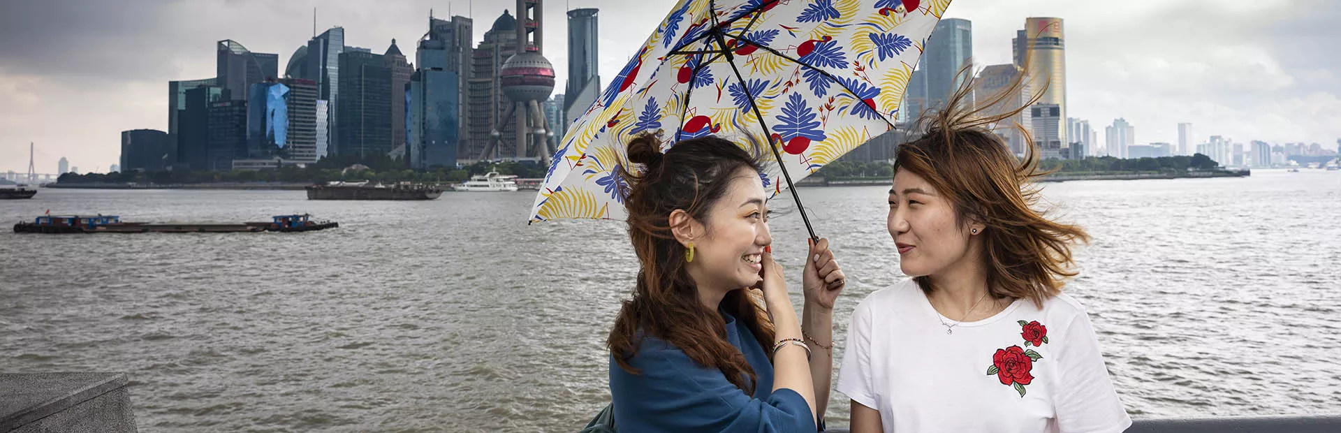 Chinese girls sharing umbrella