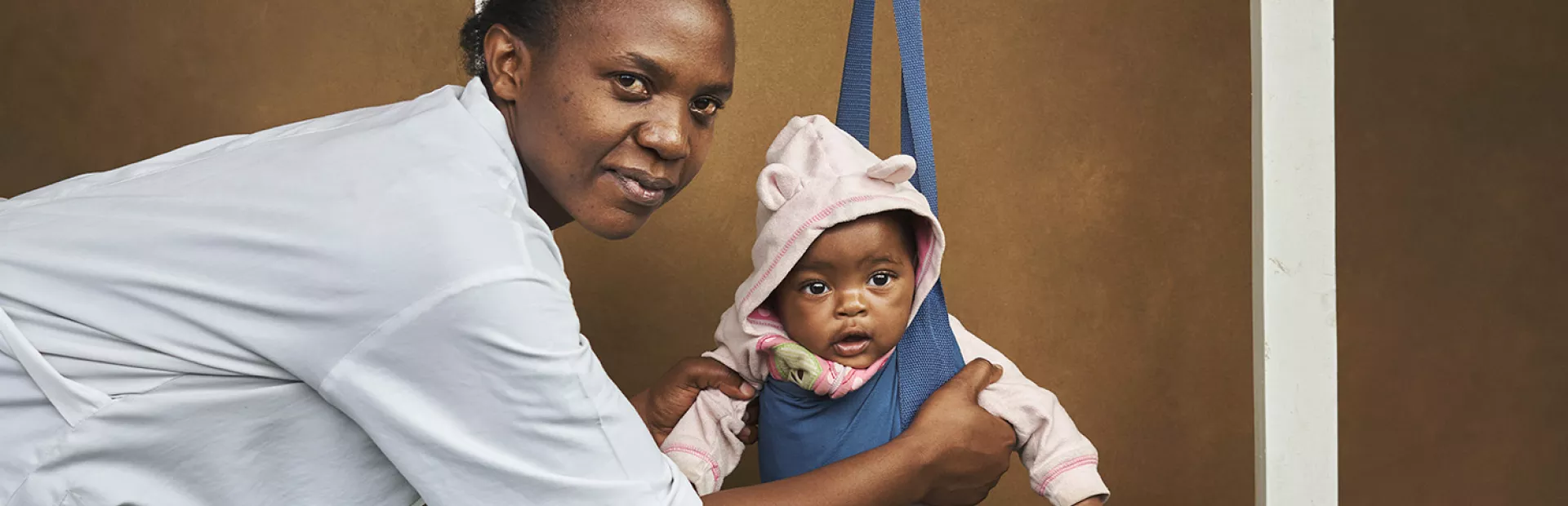 Doctor in Rwanda weighing a baby
