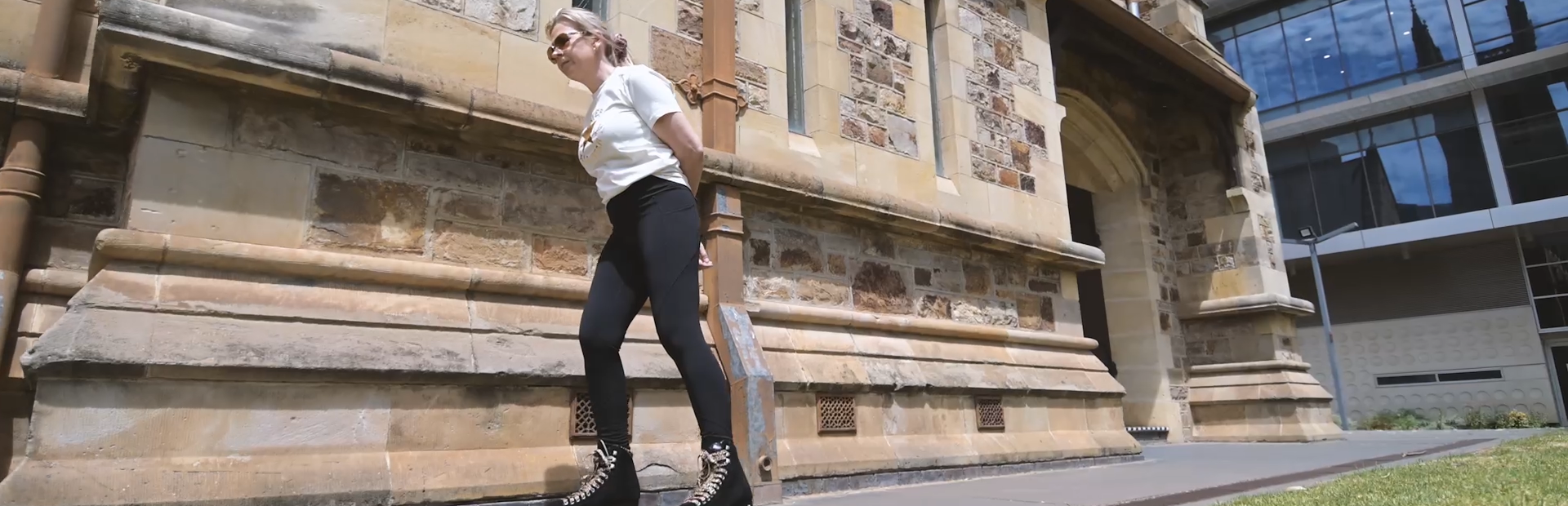 Victoria roller skates past a historic stone building