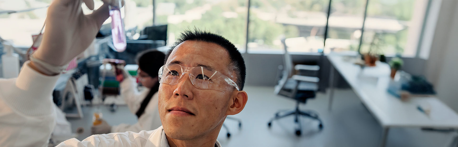 Scientist looking at a test tube with liquid as he holds it in a Novartis lab. Across R&D, our scientists are pushing the boundaries of science to discover and develop breakthrough medicines, moving from molecule to patient with urgency to help people live better, not just longer.