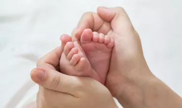Mum holding newborn's feet