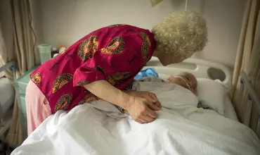 Elder woman holding the hand of a patient