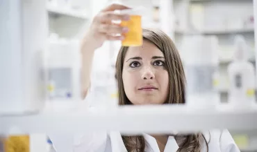 A pharmacist examining a prescription bottle