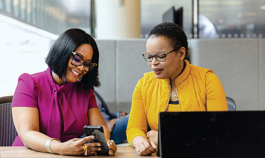 Two women in a conversation, looking at a phone
