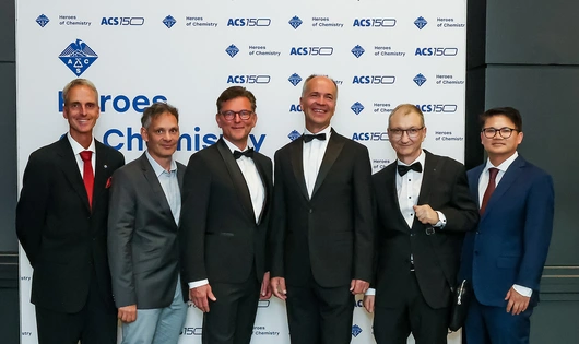 Novartis chemists receive ACS Heroes of Chemistry award at an award ceremony. Their work led to a new therapeutic approach for people living with chronic myeloid leukemia (CML). Six of the awardees are shown here posing for photos at the event: from left to right, Robert Grozfeld, Xavier Pelle, Andreas Marzinzik, Wolfgang Jahnke, Joseph Schoepfer, and Barun Okram.