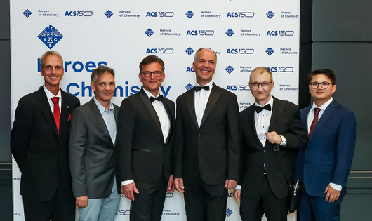 Novartis chemists receive ACS Heroes of Chemistry award at an award ceremony. Their work led to a new therapeutic approach for people living with chronic myeloid leukemia (CML). Six of the awardees are shown here posing for photos at the event: from left to right, Robert Grozfeld, Xavier Pelle, Andreas Marzinzik, Wolfgang Jahnke, Joseph Schoepfer, and Barun Okram.