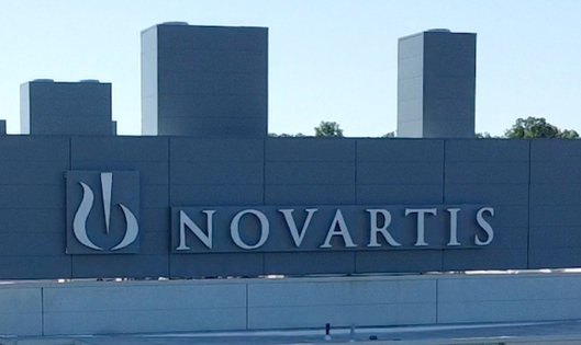 NOVARTIS logo on a large gray building facade under a clear sky
