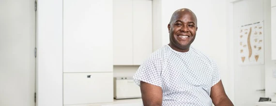 A male patient sitting in a doctor’s office