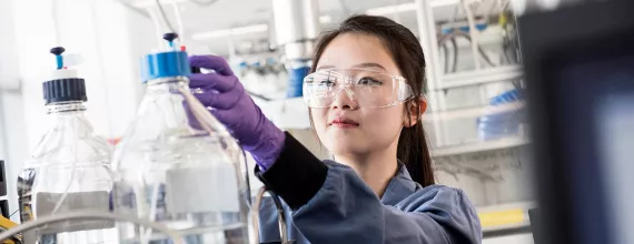 Scientist with purple gloves working in a lab