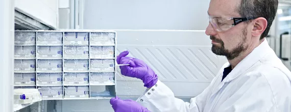 A male Novartis scientist holding multiple lab samples