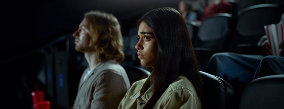 Young woman at the cinema looking puzzled