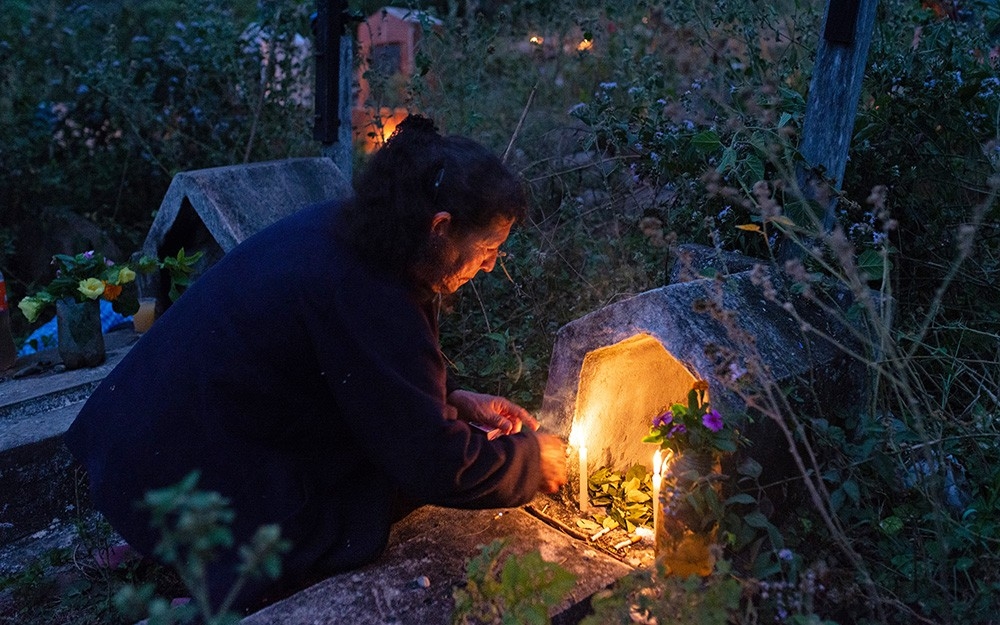 Julia lights candles for her parents who died from Chagas disease.