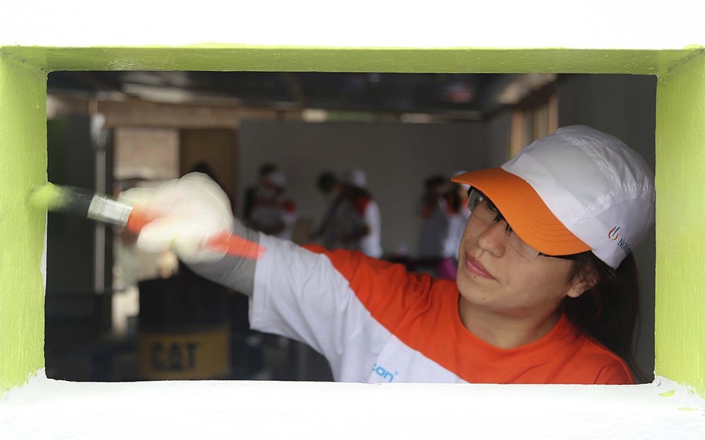 A Novartis employee paints a window frame