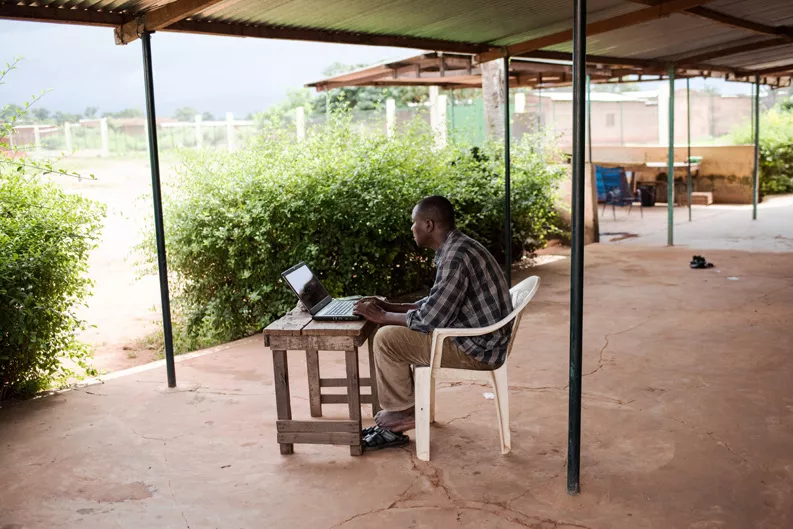 Dr. Bakary Fofana sits at a computer in Sikasso.