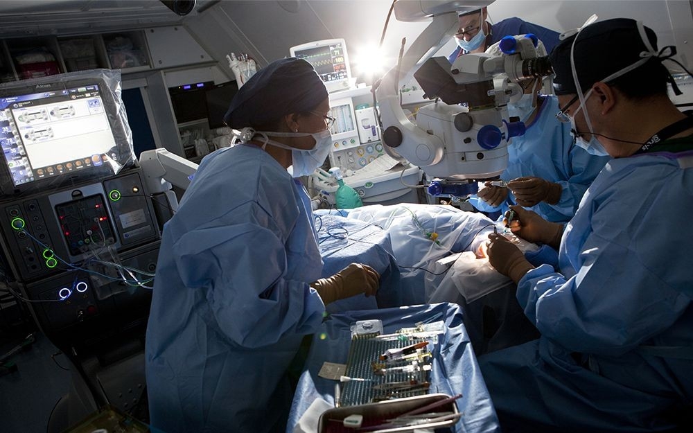 Several doctors in training work together with their teacher during an eye surgery