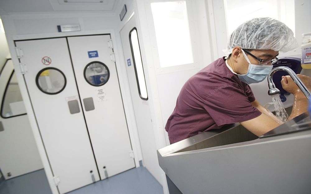 Dr. Zhang washes up before an eye procedure