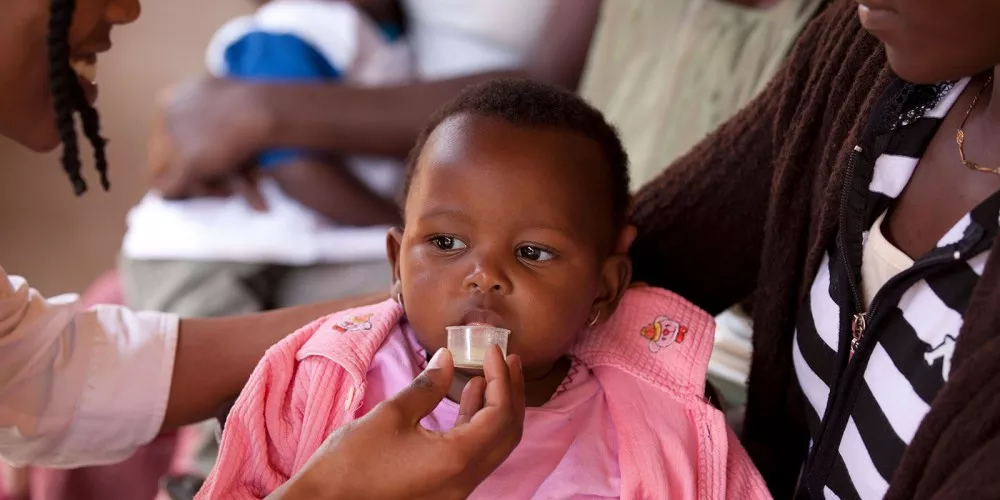 Child receives dispersible antimalarial treatment in Kenya