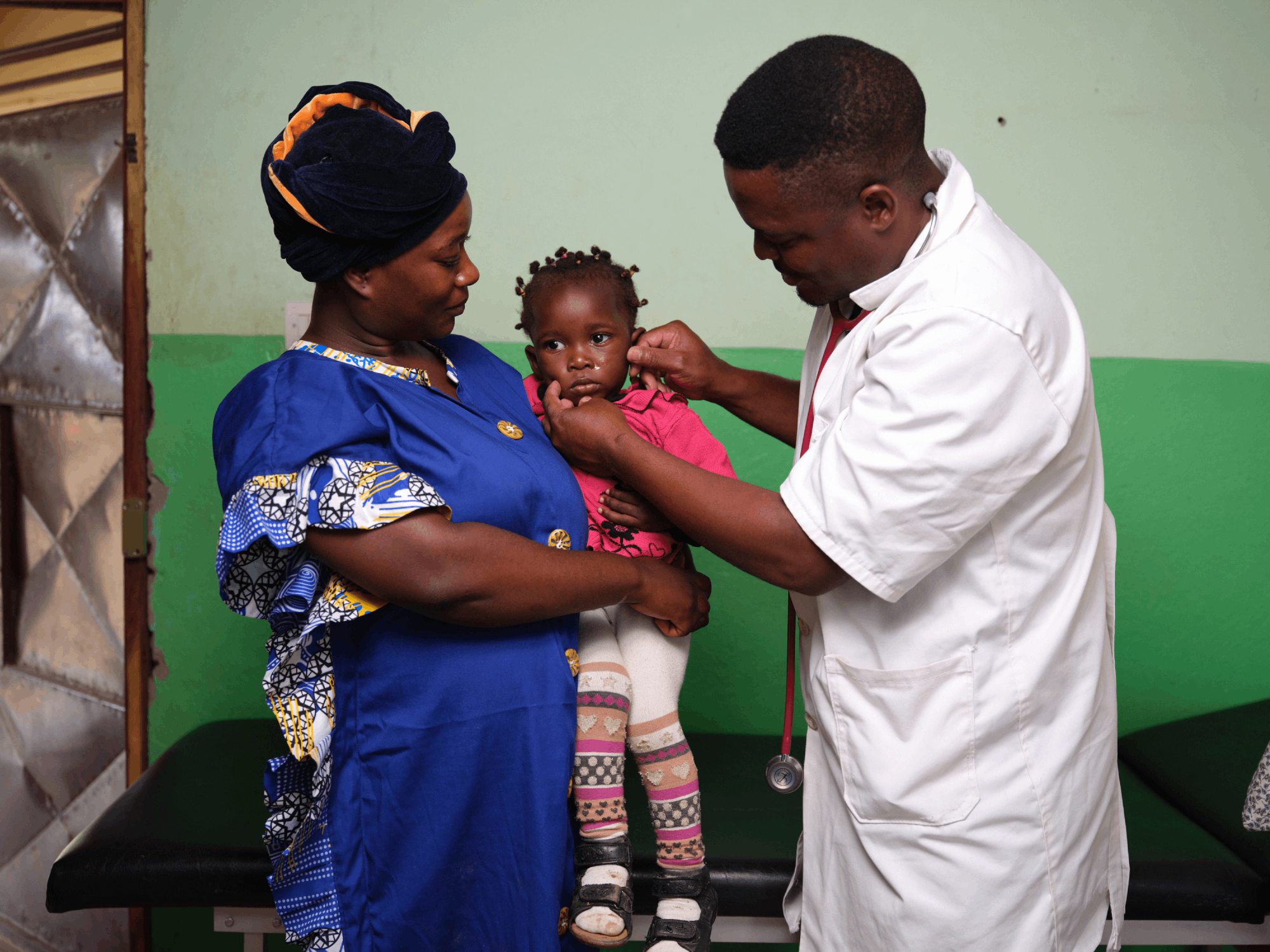 Richard Bitomo examines a child at the health center