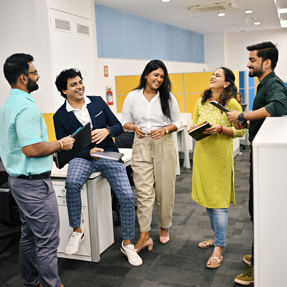 Group of five business people in India discussion and laughing