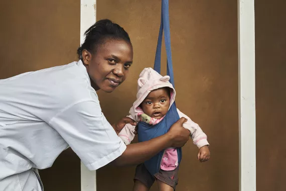 Doctor in Rwanda weighing a baby