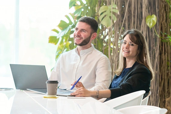 students sitting on a table with a laptop and coffee
