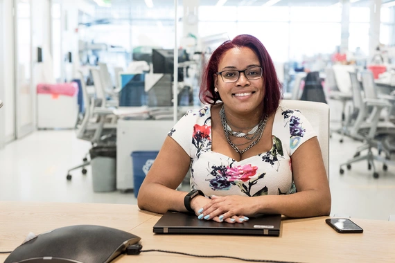 Business woman smilling and sitting with her hands on laptop