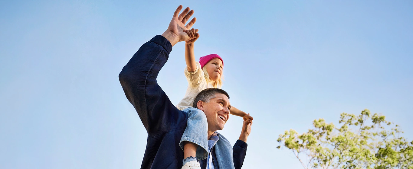 Happy father with daughter on his shoulders