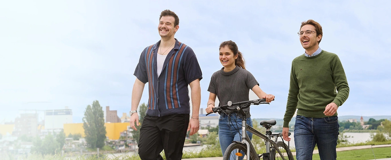 Young people walking in park with a bicycle