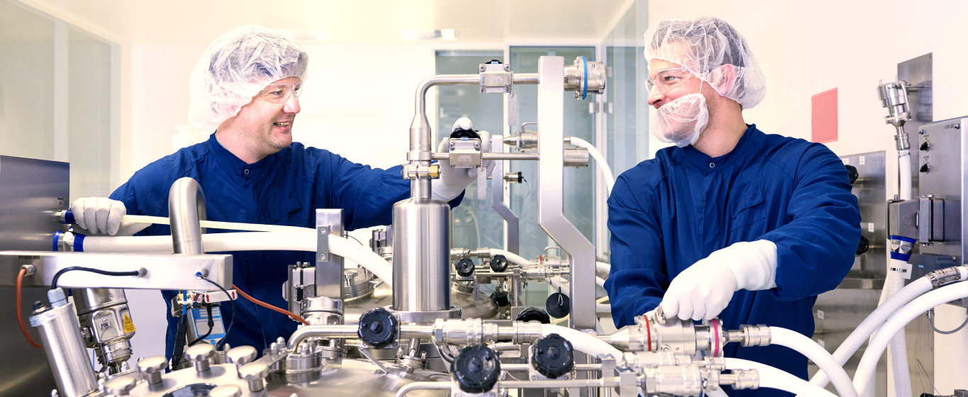 Operations technicians working in a manufacturing setting with advanced equipment