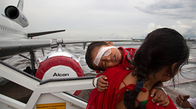 Woman carrying child with eye bandage off airplane Woman carrying child with eye bandage off airplane