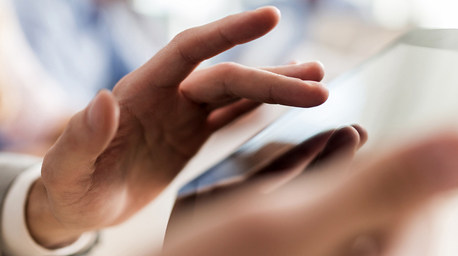 Narrow photography of a man using a tablet