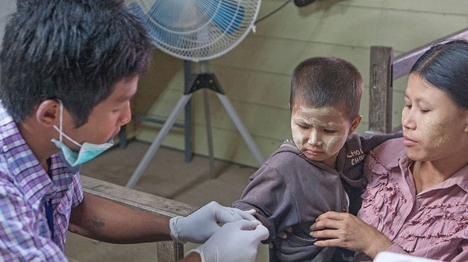 Young child next to his mother getting examine Young child next to his mother getting examine