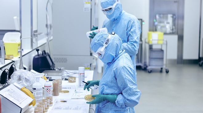 A process operator labels culture plates for environmental monitoring