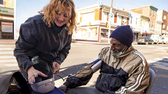 Back cover of the Annual Report 2022. Maggie Perez, a community health worker in Philadelphia, PA, checks the blood pressure of a local resident