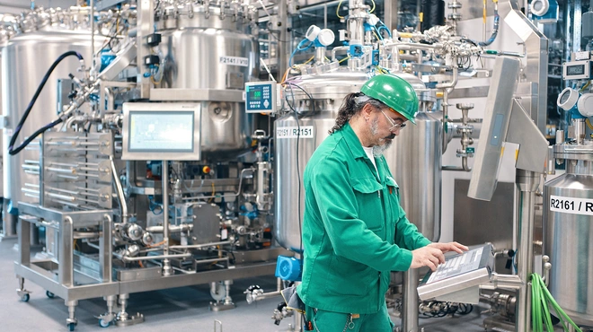 Production specialist on a computer working on RNA production in Schweizerhalle, Switzerland