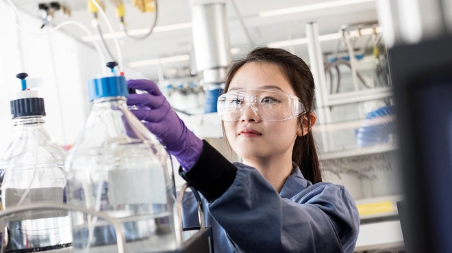 Scientist with purple gloves working in a lab