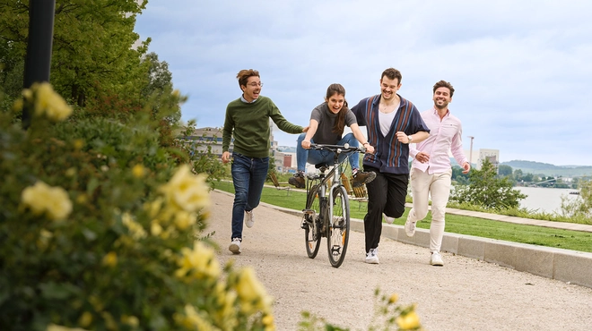 young people running and cycling in a park